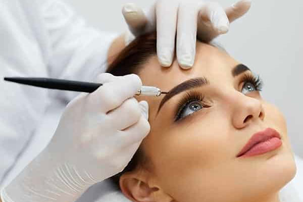 Beauty expert carefully shaping a client’s eyebrows