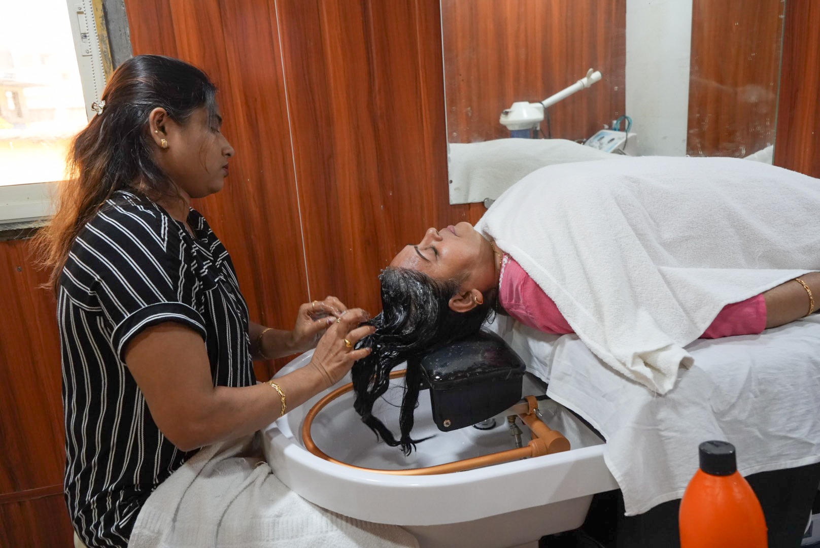 Beauty professional demonstrating a hair spa treatment technique at Dr Padma’s Academy